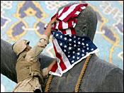 US soldier placing flag over statue of Saddam